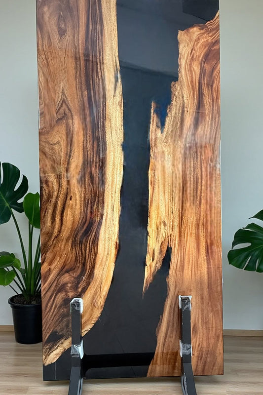 Wooden cabinet with black resin finish and metal legs against a white wall.